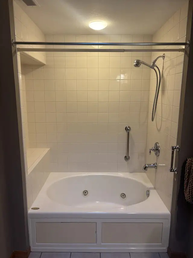 Before photo of a Boardman, Ohio bathroom with an old jetted tub and white square tile walls